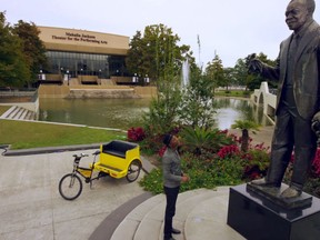 This undated image taken from video and provided by Brand USA is from the new IMAX movie called "America's Musical Journey" and shows musician Aloe Blacc in New Orleans looking at a statue of the late Louis Armstrong. The movie premieres Thursday, Feb. 15, 2018, and was produced by Brand USA, the agency that markets the U.S. to the rest of the world, along with MacGillivray Freeman Films. The movie follows Blacc as he travels around the U.S., learning about the musical heritage and genres of music associated with various cities. (Brand USA via AP)