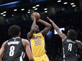 Los Angeles Lakers forward Julius Randle (30) goes to the basket against Brooklyn Nets guard Spencer Dinwiddie (8) and forward DeMarre Carroll (9) during the first half of an NBA basketball game Friday, Feb. 2, 2018, in New York.