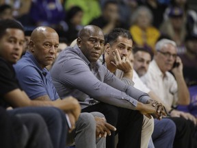 FILE - In this Oct. 4, 2017 file photo Los Angeles Lakers general manager Rob Pelinka, center right, and Magic Johnson watch the team's NBA preseason basketball game against the Denver Nuggets in Ontario, Calif. The Lakers have been fined $50,000 for violating the NBA's tampering rule again. League officials made the announcement Tuesday, Feb. 6, 2018 in response to an interview Johnson did with ESPN.