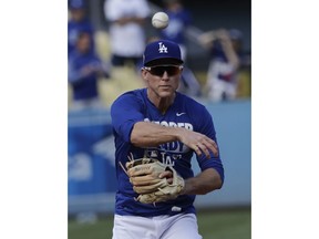 FILE - This Nov. 1, 2017 file photo shows Los Angeles Dodgers' Chase Utley warming up before Game 7 of baseball's World Series against the Houston Astros in Los Angeles. Utley appears headed back to the Los Angeles Dodgers. The free-agent infielder's gloves and cleats were in the Dodgers clubhouse on Tuesday, Feb. 13, 2018 and mail addressed to him was in a dressing stall.