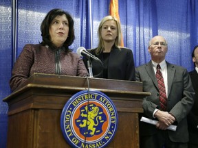 FILE - In this Jan. 11, 2018 file photo, Nassau County District Attorney Madeline Singas, left, speaks to reporters during a news conference in Mineola, N.Y., where it was announced that a grand jury had indicted alleged members of the notoriously violent MS-13 gang on a slew of charges including murder, conspiracy to commit murder and drug trafficking. A sweep of alleged MS-13 gang members on Long Island has racked up impressive arrest totals but also left unanswered questions. Since May, federal authorities say they've arrested more than 220 members of the notorious street gang. But authorities have largely declined multiple requests by for even the most basic information about the arrests.