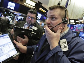 Trader Michael Milano, right, works on the floor of the New York Stock Exchange, Thursday, Feb. 8, 2018. U.S. stocks are lower Thursday morning as losses from the previous day continue.