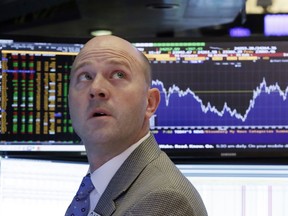 Specialist Jay Woods works at his post on the floor of the New York Stock Exchange, Friday, Feb. 9, 2018, as the chart behind him shows the day's Dow Jones industrial average volatility.