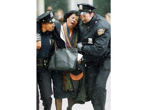 FILE - In this Feb. 26, 1993 file photo, two New York City police officers help an injured women away from the scene of the World Trade Center truck bomb attack. It was a terror attack that foreshadowed Sept. 11: the deadly World Trade Center bombing that happened 25 years ago Monday.