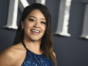 FILE - In a Tuesday, Feb. 13, 2018 file photo, actress Gina Rodriguez arrives at the Los Angeles premiere of "Annihilation" at the Regency Village Theatre. Rodriguez is set to host the 20th Costume Designers Guild Awards Tuesday night, Feb. 20, 2018,  at the Beverly Hilton Hotel in Beverly Hills, California.