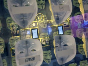 In this Monday, Feb. 12, 2018 photo, Guy Fawkes masks, often associated with the hacker group Anonymous, are displayed in a section about hacking at SPYSCAPE in New York. Visitors to a new attraction opening in New York City can learn about the elements of spying, its history and find out what kind of spy they could be. SPYSCAPE opens Friday.