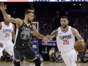 Los Angeles Clippers' Austin Rivers (25) dribbles next to Golden State Warriors' Stephen Curry (30) during the first half of an NBA basketball game Thursday, Feb. 22, 2018, in Oakland, Calif.