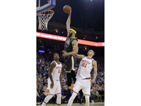 Golden State Warriors' JaVale McGee, center, dunks past Phoenix Suns' Marquese Chriss (0) and Alex Len (21) during the first half of an NBA basketball game Monday, Feb. 12, 2018, in Oakland, Calif.