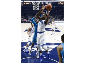 Xavier's Tyrique Jones (0) shoots against Georgetown's Marcus Derrickson, center left, during the first half of an NCAA college basketball game Saturday, Feb. 3, 2018, in Cincinnati.