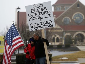 Bob Votruba, right, and his nephew Mason Miller, 13, stand outside of St. Paul the Apostle Catholic Church in in Westerville, Ohio, before the start of funeral services for Westerville police officers Anthony Morelli and Eric Joering at the church Friday, Feb. 16, 2018.  The two veteran officers were shot after entering a residence early Saturday afternoon.