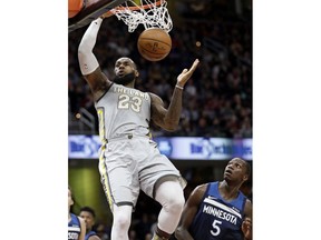 Cleveland Cavaliers' LeBron James (23) dunks the ball against Minnesota Timberwolves' Gorgui Dieng (5), from Senegal, in the first half of an NBA basketball game, Wednesday, Feb. 7, 2018, in Cleveland.