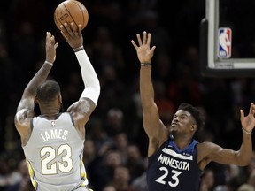 Cleveland Cavaliers' LeBron James, left, shoots over Minnesota Timberwolves' Jimmy Butler for the game-winning basket in overtime of an NBA basketball game, Wednesday, Feb. 7, 2018, in Cleveland. The Cavaliers won 140-138 in overtime.