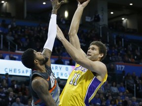 Los Angeles Lakers center Brook Lopez (11) shoots as Oklahoma City Thunder forward Paul George, left, defends in the first half of an NBA basketball game in Oklahoma City, Sunday, Feb. 4, 2018.