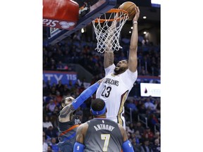 New Orleans Pelicans forward Anthony Davis (23) is fouled by Oklahoma City Thunder center Steven Adams, rear, as he dunks during the first half of an NBA basketball game in Oklahoma City, Friday, Feb. 2, 2018.