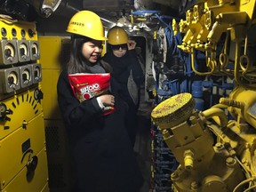 In this Sunday, Feb. 18, 2018 photo, visitors walk inside a North Korean submarine which is on display at the seaside "Unification Park" in Gangneung, South Korea, where the Olympics' skating, hockey and curling events are held. This 35-meter submarine ran aground in 1996 during an espionage mission in the area. Its 26 crew members abandoned the vessel and went into nearby rugged, heavily wooded mountains.
