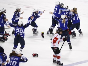 Canada's Meghan Agosta(2) skates away as the United States players celebrate after winning the women's gold medal hockey game against Canada at the 2018 Winter Olympics in Gangneung, South Korea, Thursday, Feb. 22, 2018.
