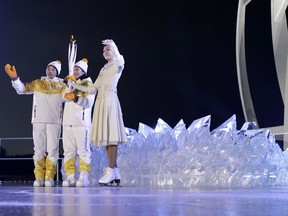 South Korean Olympic figure skating champion Yuna Kim, right, takes the tourch from North Korea's Jong Su Hyon, left, and South Korea's Park Jong-ah during the opening ceremony of the 2018 Winter Olympics in Pyeongchang, South Korea, Friday, Feb. 9, 2018.