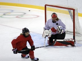 Canada's Meghan Agosta, left, chases the puck as goalie Ann-Reneeat Desbiens watches during the women's hockey practice ahead of the 2018 Winter Olympics in Gangneung, South Korea, Friday, Feb. 9, 2018.