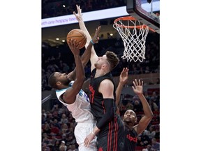 Charlotte Hornets forward Michael Kidd-Gilchrist, left, shoots over Portland Trail Blazers center Jusuf Nurkic, center, and forward Maurice Harkless, right, during the first half of an NBA basketball game in Portland, Ore., Thursday, Feb. 8, 2018.