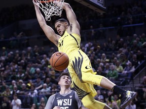 Oregon's Keith Smith, top, dunks over Washington State's Carter Skaggs during the first half of an NCAA college basketball game Sunday, Feb. 11, 2018, in Eugene, Ore.