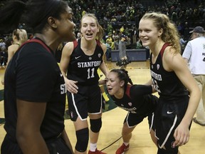 Stanford's Nadia Fingall, left, Alanna Smith, and Marta Sniezek celebrate with Brittany McPhee, right, after she led the team in scoring to defeat Oregon in an NCAA college basketball game in Eugene, Ore., Sunday, Feb 4, 2018.