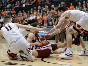 Washington State's Malachi Flynn center, tries to protect the ball from Oregon State's Zach Reichle (11) and Drew Eubanks, right, in the first half of an NCAA college basketball game in Corvallis, Ore., Thursday, Feb. 8, 2018.