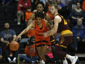 Oregon State's Stephen Thompson Jr., center, protects the ball from Arizona State's Kimani Lawrence, rear, and Kodi Justice, right, in the first half of an NCAA college basketball game in Corvallis, Ore., Saturday, Feb. 24, 2018.
