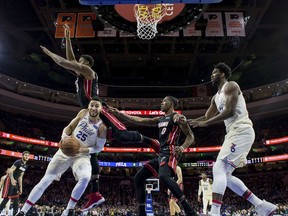 Philadelphia 76ers' Ben Simmons,, left, tries to go up for a shot as Miami Heat's Hassan Whiteside, center left, goes flying over him, with Josh Richardson, center right, and 76ers' Joel Embiid, right, watching during the first half of an NBA basketball game Friday, Feb. 2, 2018, in Philadelphia.