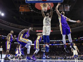 Philadelphia 76ers' Joel Embiid, center, of Cameroon, dunks after getting past New Orleans Pelicans' Nikola Mirotic, right, of Montenegro, during the first half of an NBA basketball game, Friday, Feb. 9, 2018, in Philadelphia.