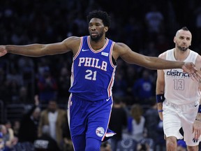 Philadelphia 76ers' Joel Embiid (21) celebrates after scoring three points while Washington Wizards' Marcin Gortat looks on in the first half of an NBA basketball game, Tuesday, Feb 6, 2018, in Philadelphia.