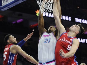 Miami Heat's Hassan Whiteside (21) dunks over Philadelphia 76ers' Dario Saric (9) and Ben Simmons (25) in the first half of an NBA basketball game, Wednesday, Feb. 14, 2018, in Philadelphia.