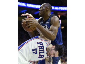 Orlando Magic's Bismack Biyombo, top, pulls in a rebound over Philadelphia 76ers' JJ Redick (17) in the first half of an NBA basketball game, Saturday, Feb. 24, 2018, in Philadelphia.