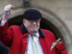 FILE - In this May 1 2017 file photo, former far-right National Front party leader Jean-Marie Le Pen clenches his fist at the statue of Joan of Arc, in Paris. A French appeals court has upheld Friday Feb.9, 2018 the far-right National Front's decision to expel party founder Jean-Marie Le Pen over anti-Semitic remarks.