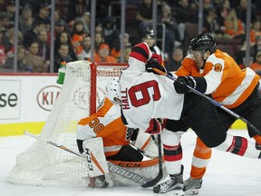 Philadelphia Flyers' Robert Hagg, right, clears New Jersey Devils' Taylor Hall from in front of the net defended by Michal Neuvirth during an NHL hockey game, Tuesday, Feb. 13, 2018 in Philadelphia.