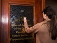 A Queen's Park legislative staff member removes former PC leader Patrick Brown's office name on Jan. 26, 2018, after he stepped down over allegations of sexual misconduct.