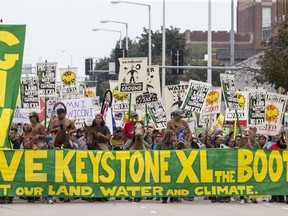 FILE--In this Aug. 6, 2017, file photo, demonstrators against the Keystone XL pipeline march in Lincoln, Neb. Opponents of the proposed  oil pipeline from Canada are asking a federal judge to force the U.S. government to turn over emails and other documents related to President Donald Trump's approval of the project.