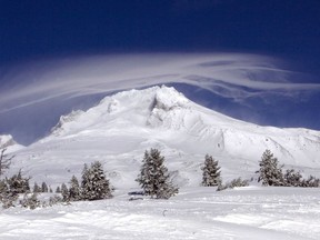 FILE - In this Dec. 13, 2009, file photo, a cloud forms over Mount Hood as seen from Government Camp, Ore. Authorities say a rescue effort is underway, Tuesday, Feb. 13, 2018, for a climber who fell on Mount Hood.