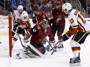Calgary Flames left wing Johnny Gaudreau (13) scores a goal against Arizona Coyotes goaltender Antti Raanta (32) as Flames center Sam Bennett (93), Coyotes defenseman Oliver Ekman-Larsson (23) and defenseman Jason Demers (55) look on during the first period of an NHL hockey game Thursday, Feb. 22, 2018, in Glendale, Ariz.
