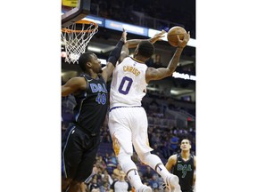 Dallas Mavericks forward Harrison Barnes (40) alters the dunk attempt by Phoenix Suns forward Marquese Chriss (0) during the first half of an NBA basketball game Wednesday, Jan. 31, 2018, in Phoenix.