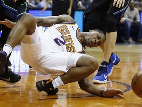 Phoenix Suns guard Isaiah Canaan injures his foot, landing awkwardly, after being fouled by the Dallas Mavericks during the first half of an NBA basketball game Wednesday, Jan. 31, 2018, in Phoenix.