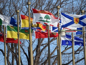 Provincial flags flap in the wind outside Government House in Edmonton.