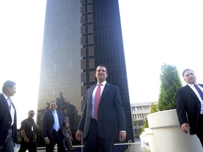 The eldest son of U.S. President Donald Trump, Donald Trump Jr. , center, stands in front of Trump Towers after its inauguration in Pune, India, Wednesday, Feb. 21, 2018. Donald Trump Jr. said any talk that his family was profiting from his father's presidency was "nonsense" as he began a visit to India to promote real estate deals that bear his family's name.