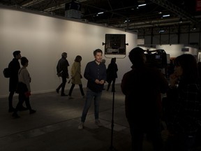 A television journalist reports in front of a blank white wall where art works by artist Santiago Sierra were hung before being taken down in a gallery on the first day of annual the ARCO International Art Fair in Madrid, Spain, Wednesday, Feb. 21, 2018. Madrid's International Art Fair has yanked an exhibition entitled "Political Prisoners in Contemporary Spain," prompting charges of censorship against the government-funded body which operates the event venue.