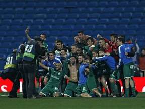 FILE - In this Jan. 24, 2018 file photo, Leganes' players celebrate their victory against Real Madrid at the end of the Spanish Copa del Rey quarterfinal second leg soccer match at the Santiago Bernabeu stadium in Madrid, Spain. The team everyone is talking about now is Leganes, the modest club based just south of the capital. It spent a decade in the third tier, from 2004-2014, before making the run that took the club to the first division in 2016.