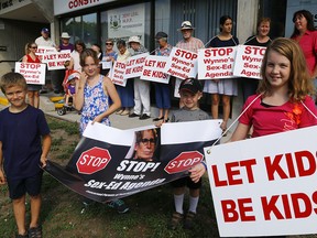 Members of Concerned Parents of Peterborough (CPP) protest outside of MPP Jeff Lealís Constituency Office on Wednesday August 31, 2016 on King St. in Peterborough, Ont.