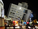 Rescuers enter a building that collapsed onto its side from an early morning 6.4 magnitude earthquake in Hualien County, eastern Taiwan, Wednesday, Feb. 7 2018.