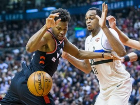 Kyle Lowry of the Raptors and the Milwaukee Bucks' John Henson keep their eyes on a loose ball during their game at the Air Canada Centre in Toronto on Friday night.