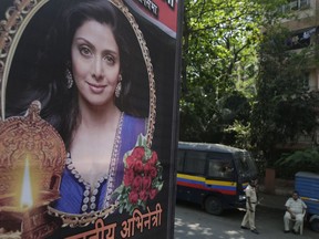 Indian policemen guard near a picture of Indian actress Sridevi displayed outside her residence in Mumbai, India, Tuesday, Feb. 27, 2018. The 54-year-old Bollywood actress died late on Saturday while on a visit to Dubai.