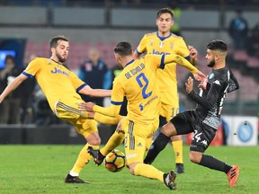 FILE - In this Dec. 1, 2017 file photo, Napoli's Lorenzo Insigne is caught in between Juventus' Miralem Pjanic, left, and Mattia De Sciglio during an Italian Serie A soccer match between Napoli and Juventus at the San Paolo stadium in Naples, Italy. The contrasts between six-time defending champion Juventus and Italian league leader Napoli are endless, yet the difference in the standings is just one point, and has been for more than two months, making Serie A by far the most competitive of Europe's five major league leagues this season.