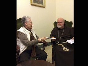 FILE - This Feb. 3, 2018 file photo shows Marie Collins, a member of the Pope Francis' sex-abuse commission, handing a letter to Cardinal Sean O'Malley detailing the abuse of Juan Carlos Cruz and a cover-up by Chilean church authorities, at the Domus Santa Marta, at the Vatican on April 12, 2015. Chilean abuse survivor Juan Carlos Cruz is to testify on Feb. 17, 2018 to a Vatican investigator gathering testimony about alleged abuse cover-up by Bishop Juan Barros.